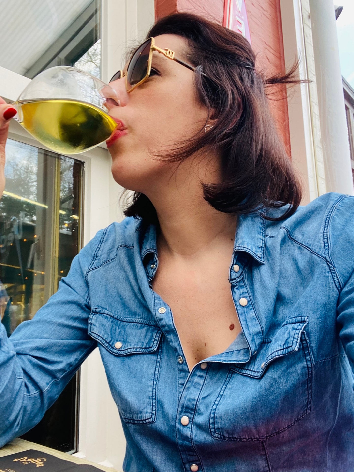 Ramona geniet van een glas wijn op een zonnig terras